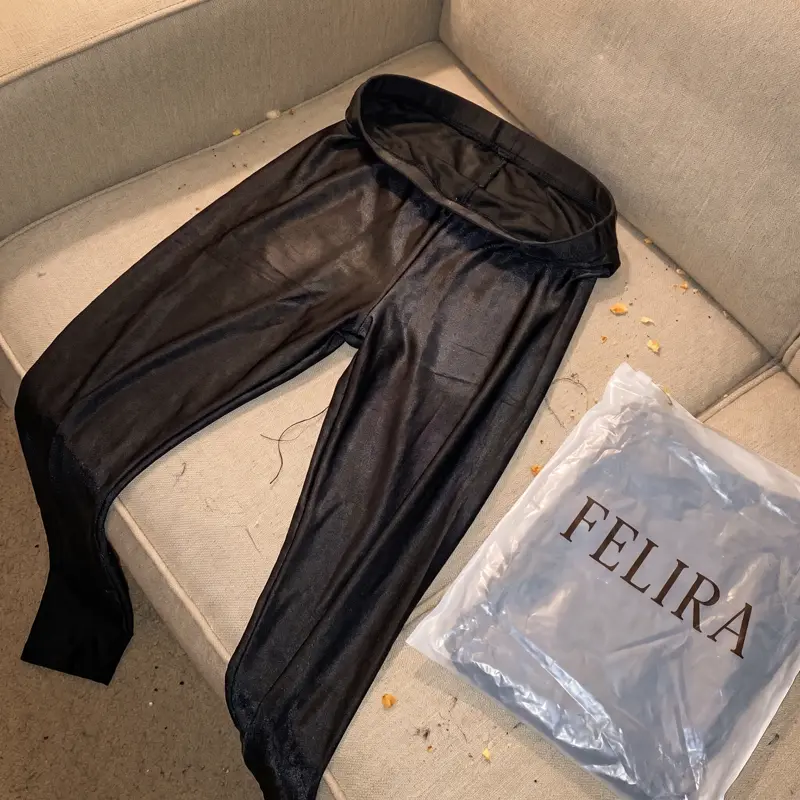Dünne glänzende Felira Leggings auf dem Sofa neben der Verpackung
